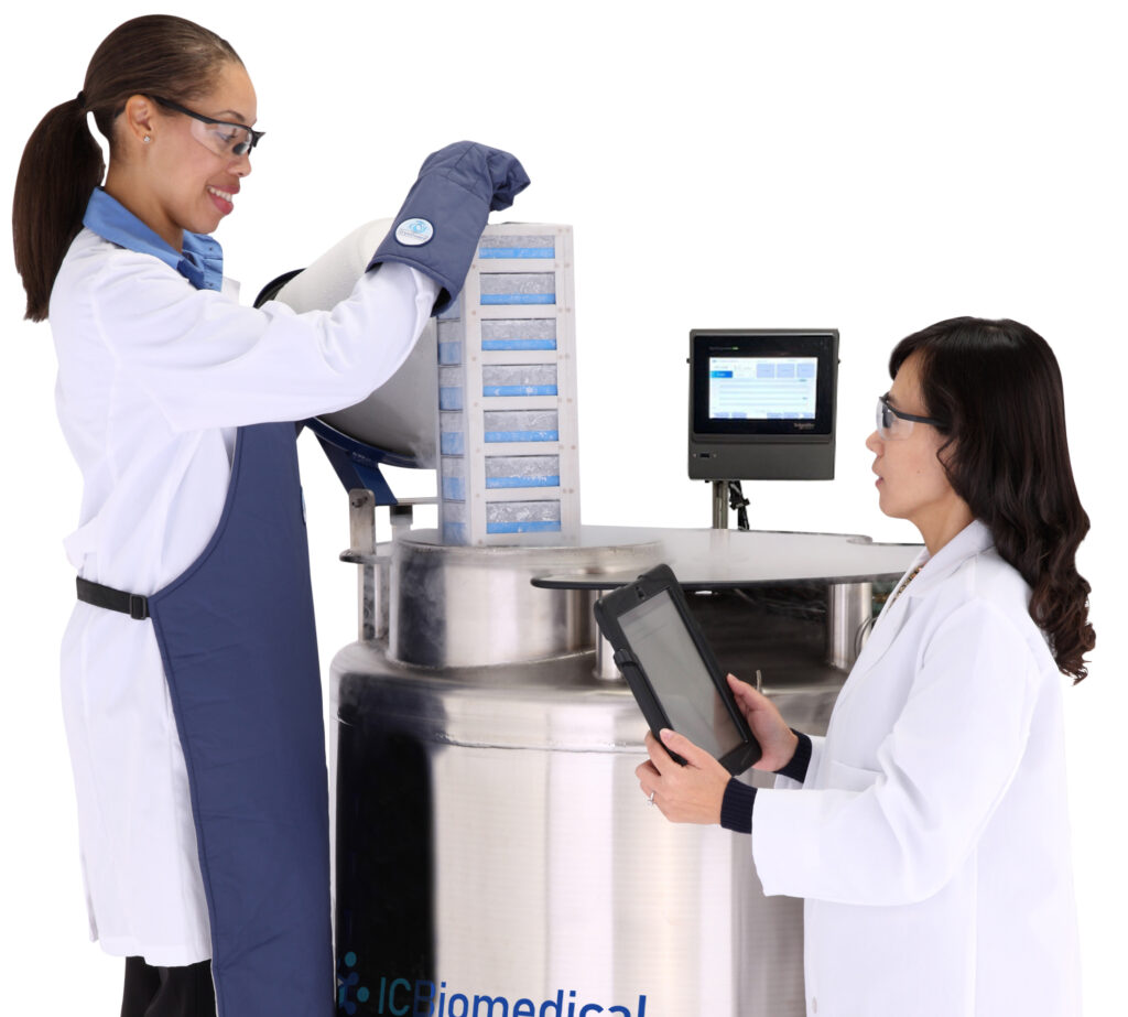 two lab scientists inspecting samples and adding to a cryogenic freezer