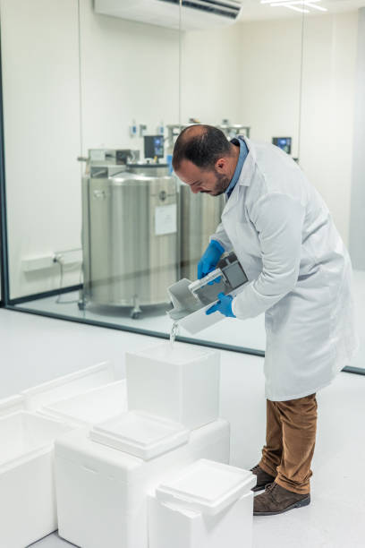 man poring liquid nitrogen into a storage vessel